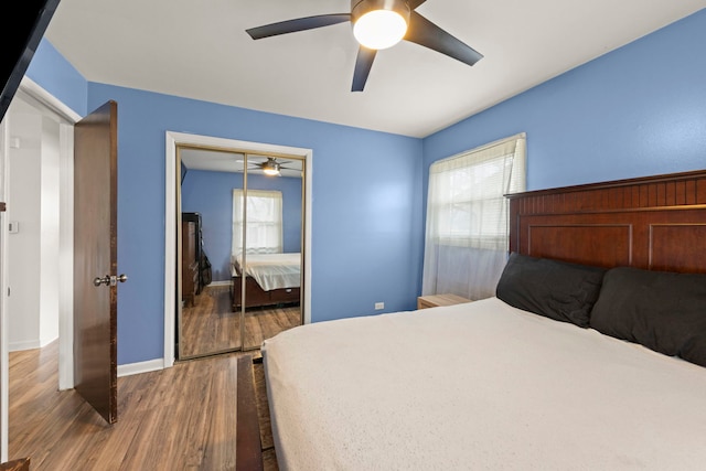bedroom featuring ceiling fan, a closet, baseboards, and wood finished floors