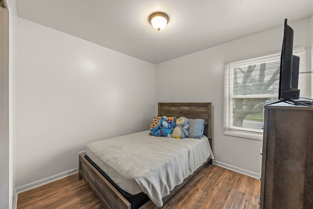 bedroom featuring dark wood-style flooring and baseboards