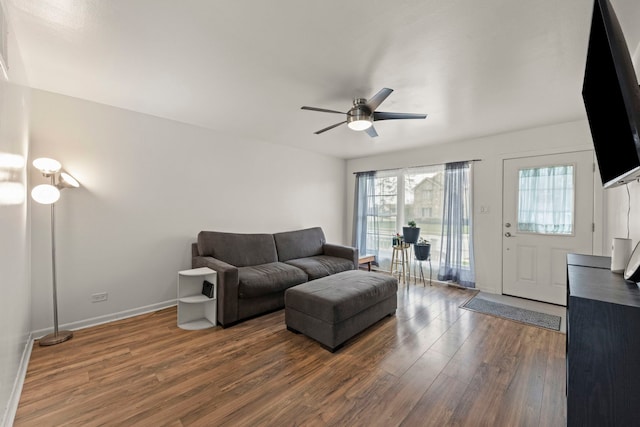 living room with baseboards, a ceiling fan, and wood finished floors