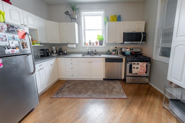 1304 N Campbell Ave, Chicago, IL 60622 - kitchen featuring light wood-style floors, a sink, white cabinetry, and appliances with stainless steel finishes