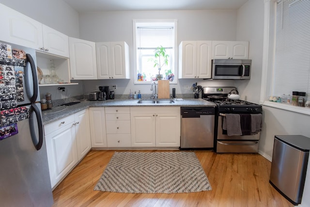 1304 N Campbell Ave, Chicago, IL 60622 - kitchen with white cabinets, light stone counters, a sink, light wood-style floors, and stainless steel appliances