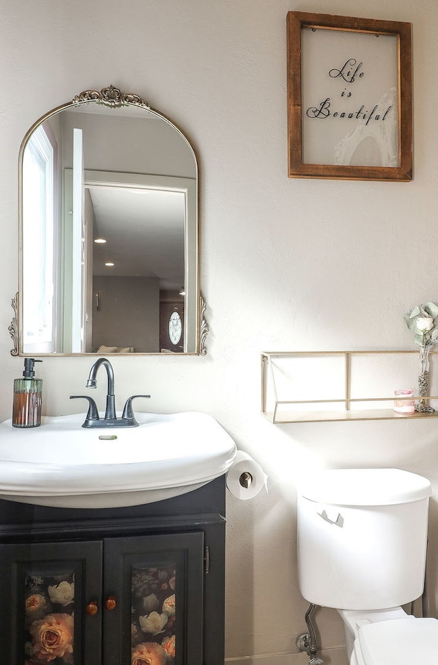 half bath featuring toilet and vanity