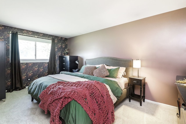carpeted bedroom featuring wallpapered walls and baseboards
