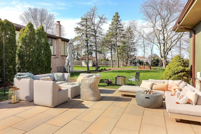 view of patio with an outdoor living space with a fire pit