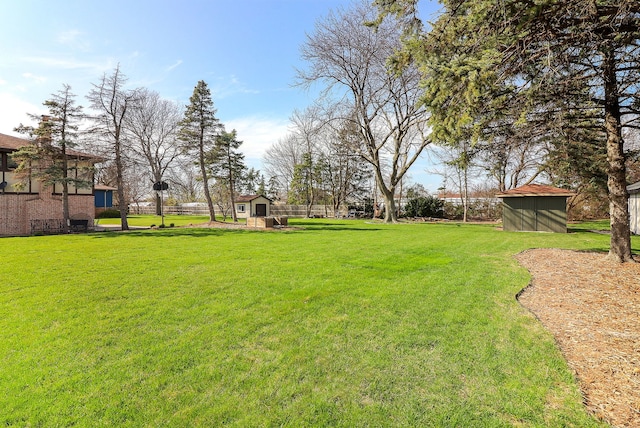 view of yard with an outbuilding, a shed, and fence