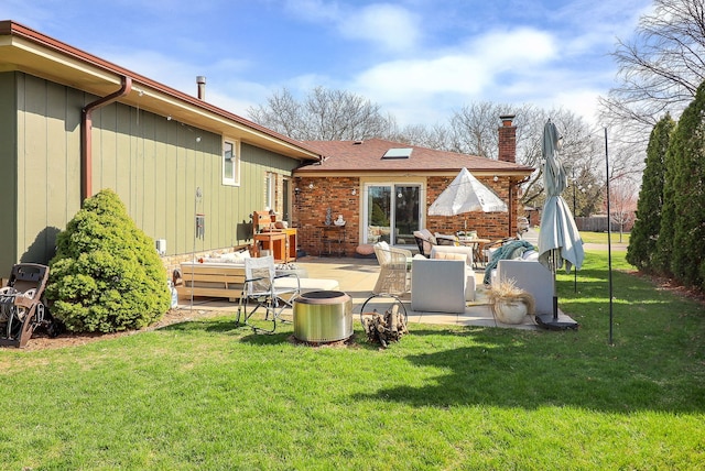 back of house with a yard, an outdoor hangout area, a patio area, and a chimney