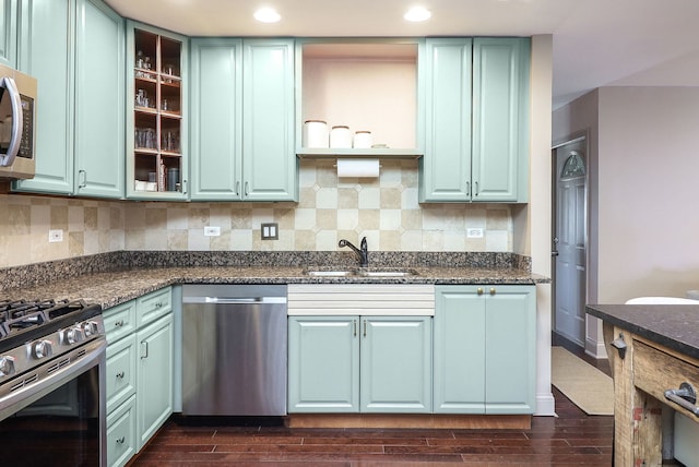 kitchen with backsplash, a sink, dark wood-type flooring, and appliances with stainless steel finishes