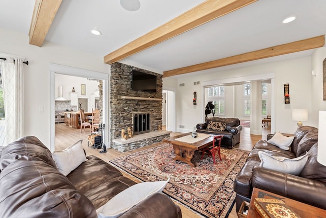 living area with beam ceiling, a fireplace, light wood-type flooring, visible vents, and recessed lighting
