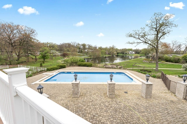 view of pool with a water view, a patio, a fenced in pool, and fence