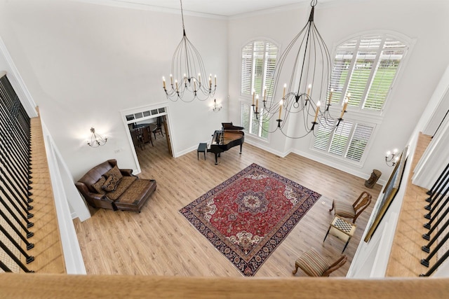 living area featuring a chandelier, stairs, ornamental molding, and wood finished floors