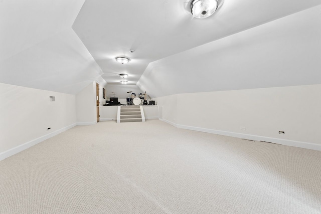 bonus room with light colored carpet, baseboards, and lofted ceiling
