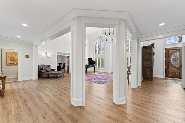 foyer entrance with an inviting chandelier and ornamental molding