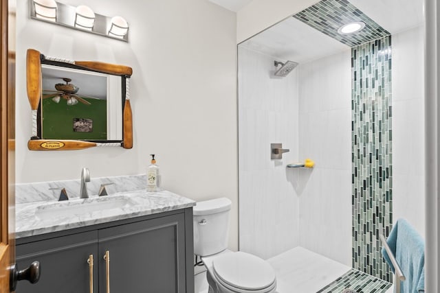 full bath with toilet, vanity, and tiled shower