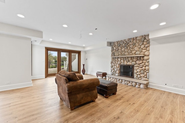 living room with a fireplace, light wood-style flooring, baseboards, and recessed lighting