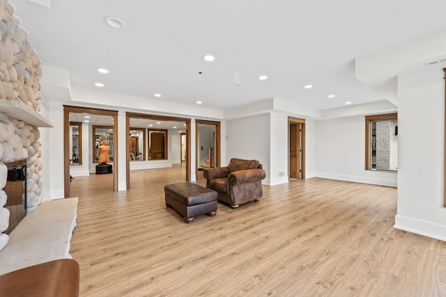 living room with baseboards, light wood finished floors, a fireplace, and recessed lighting