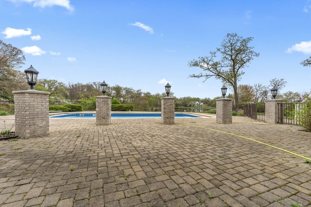 view of property's community with a patio area, fence, and a swimming pool