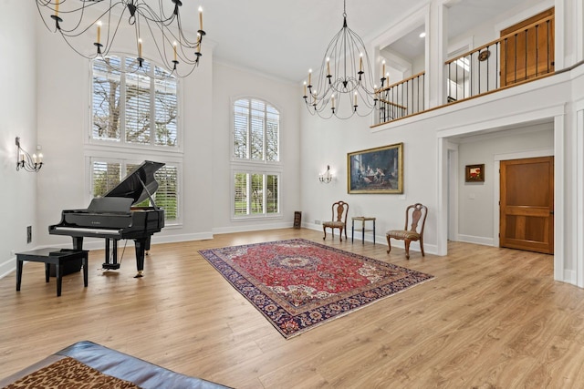 living area featuring a chandelier, baseboards, and a towering ceiling