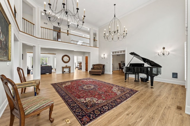 interior space with baseboards, ornamental molding, a chandelier, and a high ceiling