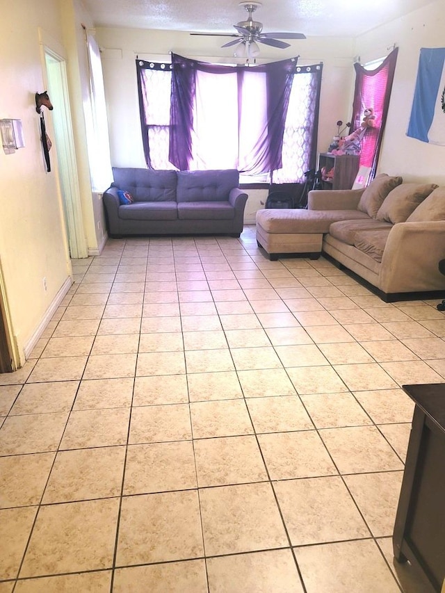 unfurnished living room featuring light tile patterned flooring, a textured ceiling, a healthy amount of sunlight, and ceiling fan