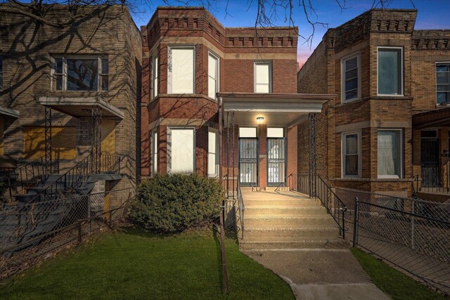 view of front of house featuring a porch, fence, and brick siding