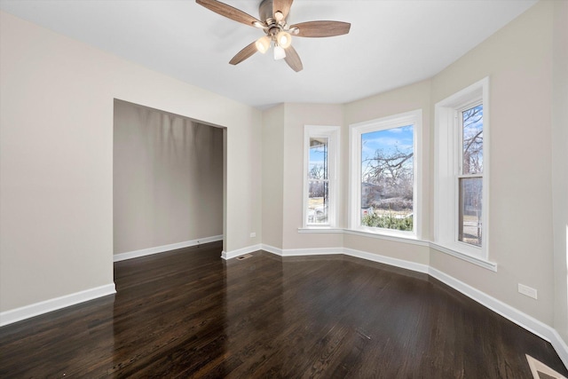unfurnished room featuring dark wood-type flooring, baseboards, and visible vents