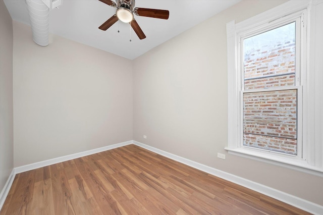 empty room with baseboards, wood finished floors, and a ceiling fan