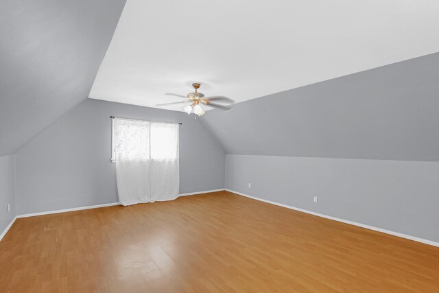 bonus room with baseboards, a ceiling fan, wood finished floors, and vaulted ceiling
