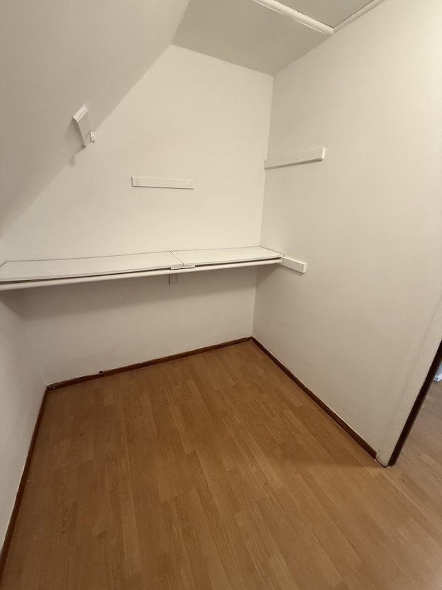 walk in closet featuring lofted ceiling and wood finished floors