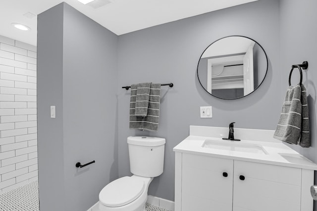 bathroom featuring visible vents, vanity, baseboards, toilet, and tiled shower