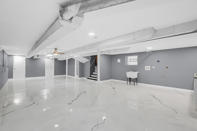 below grade area featuring a sink, baseboards, and stairs