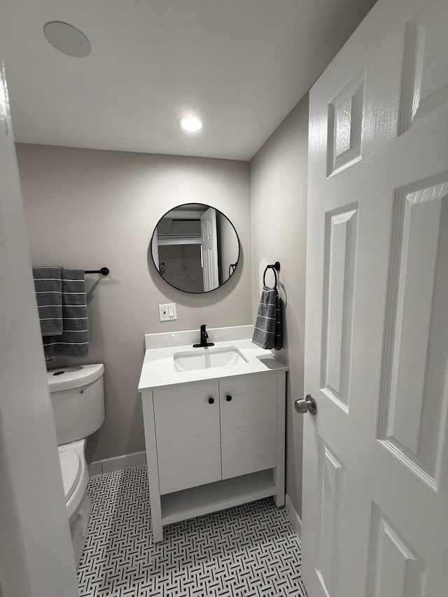 bathroom with toilet, baseboards, recessed lighting, and vanity