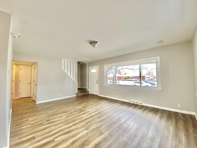 351 Clyde Ave, Calumet City, IL 60409 - unfurnished living room featuring wood finished floors, visible vents, stairway, and baseboards