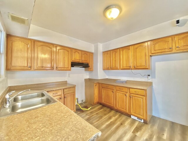 351 Clyde Ave, Calumet City, IL 60409 - kitchen with visible vents, under cabinet range hood, dishwasher, light wood finished floors, and brown cabinetry