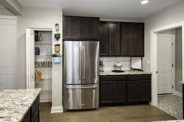 kitchen featuring light stone counters, recessed lighting, light wood-style flooring, and high quality fridge