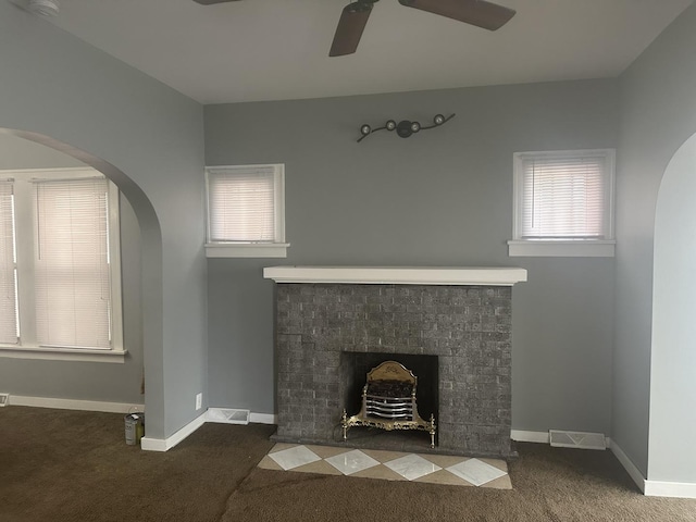 651 Douglas Ave, Calumet City, IL 60409 - unfurnished living room featuring a fireplace with flush hearth, arched walkways, ceiling fan, and carpet