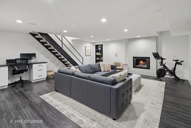living area with stairs, a fireplace, dark wood-type flooring, baseboards, and recessed lighting