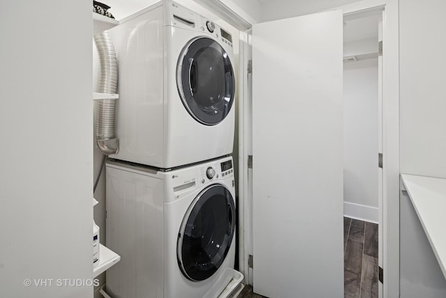 washroom with stacked washer / dryer, laundry area, and wood finished floors