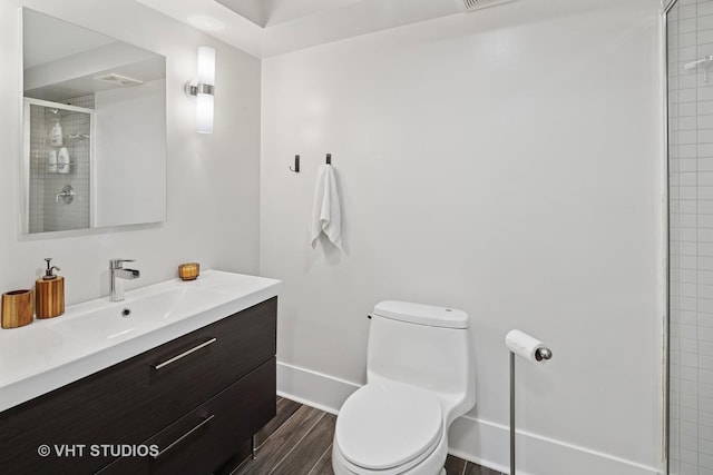 full bathroom featuring toilet, a stall shower, baseboards, and wood finished floors