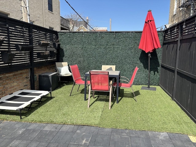 view of yard with outdoor dining area and a fenced backyard