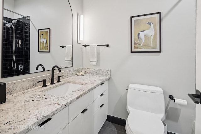 bathroom with baseboards, toilet, tile patterned flooring, and vanity