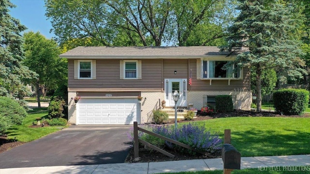 602 S Vista Dr, Algonquin, IL 60102 - raised ranch featuring a garage, asphalt driveway, a front yard, brick siding, and entry steps