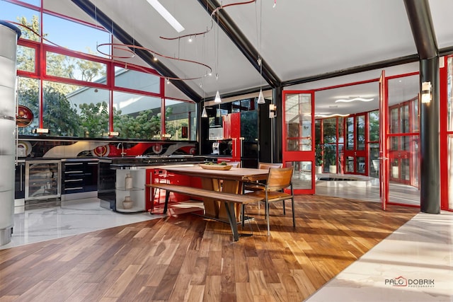 dining area with wine cooler, a skylight, and wood finished floors