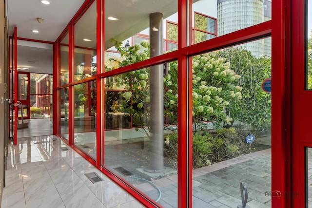 entryway featuring a wall of windows, recessed lighting, visible vents, and marble finish floor