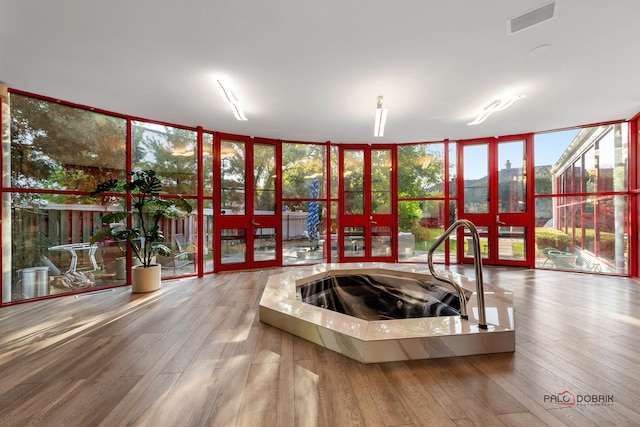 sunroom / solarium with a sink, visible vents, and french doors