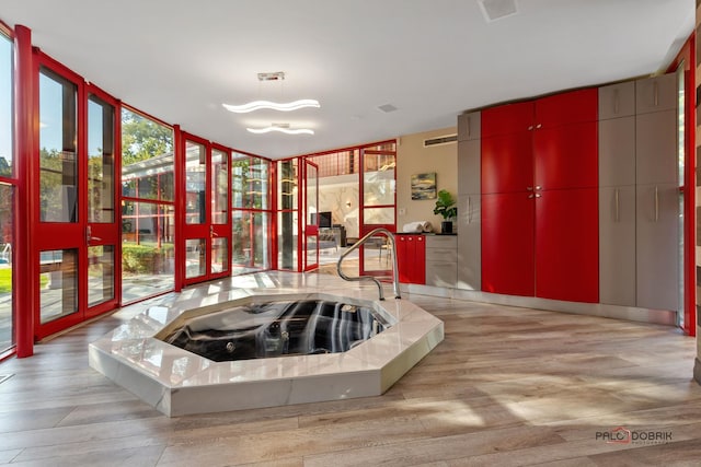foyer with expansive windows, visible vents, and wood finished floors