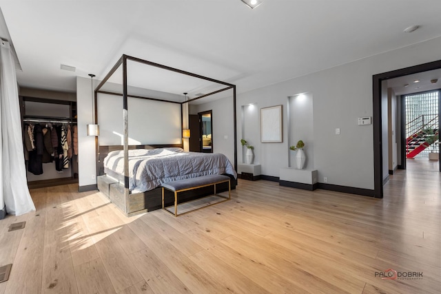bedroom featuring visible vents, baseboards, and light wood finished floors
