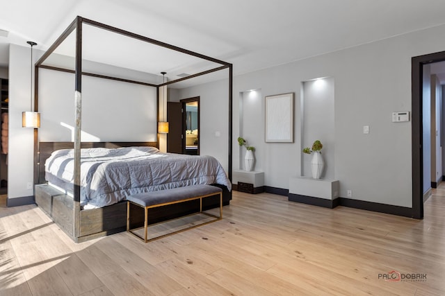 bedroom featuring wood finished floors and baseboards