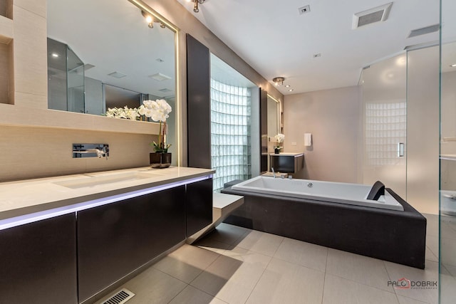 full bathroom with tile patterned floors, visible vents, vanity, and a tub to relax in