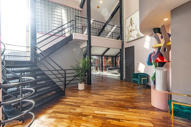 staircase featuring a high ceiling and wood finished floors