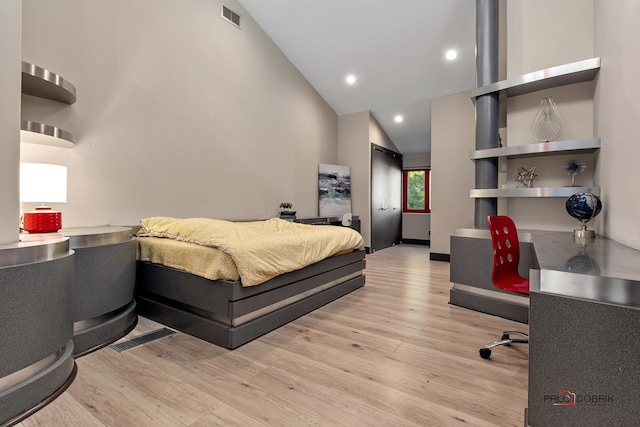 bedroom featuring light wood finished floors, visible vents, recessed lighting, and high vaulted ceiling